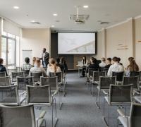 uczestnicy szkolenia w sali z krzesłami ustawionymi w rzędach