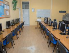 Sala komputerowa do wynajęcia w Zamościu, widok na stanowiska komputerowe, tablice suchościeralną oraz drzwi wejściowe do sali
