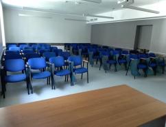 Sala szkoleniowa znajdująca się w budynku WSB w Gdańsku przy al. Grunwaldzkiej, widok na krzesła tapicerowane z pulpitami oraz rzutnik
