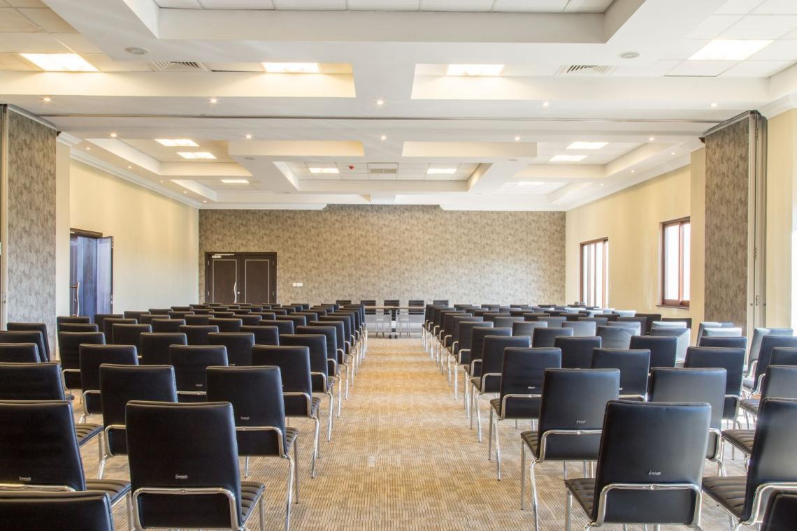 pusta sala konferencyjna z krzesłami w ustawieniu teatralnym