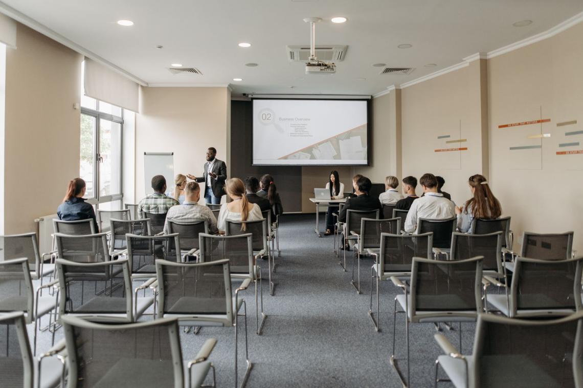 uczestnicy szkolenia w sali z krzesłami ustawionymi w rzędach